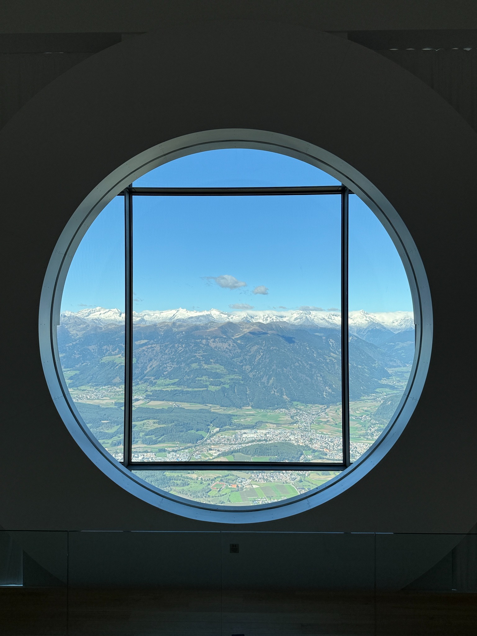 Originalfoto: Rundes Fenster mit Bergblick